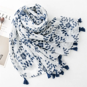 Detail of blue floral print on linen cotton scarf with dark blue handmade tassels