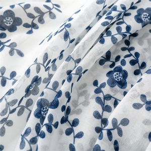 Detailed macro view of soft cotton-linen fabric with blue floral patterns on a scarf