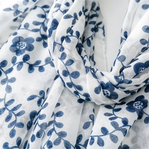 Close-up of lightweight cotton scarf showing blue floral prints and woven texture
