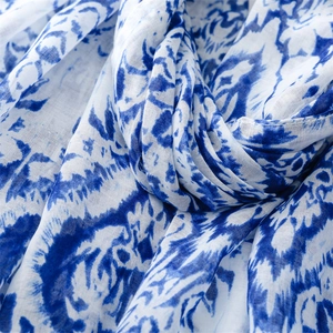 Macro detail of breathable cotton-linen scarf with blue tie-dye pattern texture