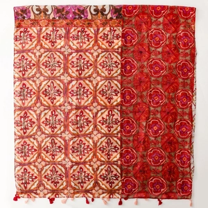 Detail of bohemian scarf with dual-print geometric patterns and red fringe tassels