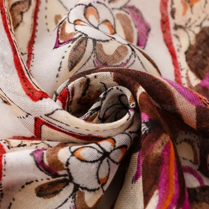 Macro detail of bohemian printed scarf with warm floral patterns and mesh texture