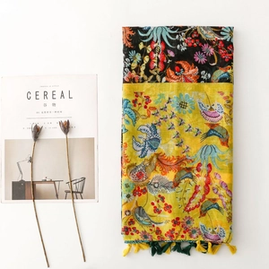 Vibrant floral and bird print scarf with fringe tassels on minimalist white background