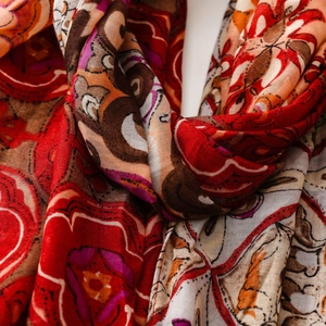 Close-up of bohemian paisley printed scarf with red floral patterns and light texture