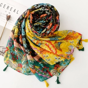 Detail of vibrant floral print scarf with hand-made tassels on a minimalist background