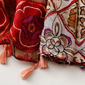 Macro shot of ethnic print scarf fabric with pink tassel fringe and vibrant colors