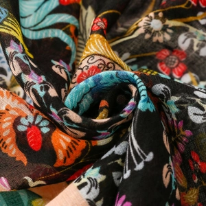 Detailed macro view of colorful floral patterns on black linen-feel scarf fabric