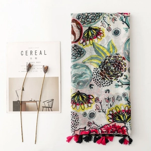 Colorful floral print scarf with fringe trim and a lightweight cotton-linen feel