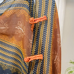 Close-up of ethnic print scarf with handmade orange Chinese frog button fasteners