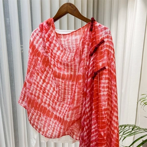 Macro detail of red and white tie-dye shawl with traditional Chinese knot buttons