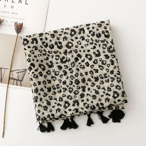 Détail de l'écharpe à motif léopard avec bordures à glands noirs et texture douce
