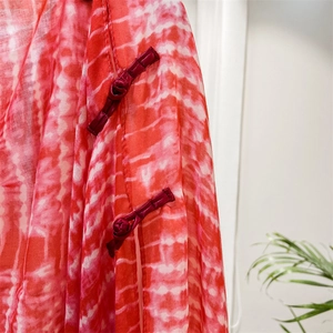 Close-up of red and white tie-dye fabric with traditional Chinese handmade knots