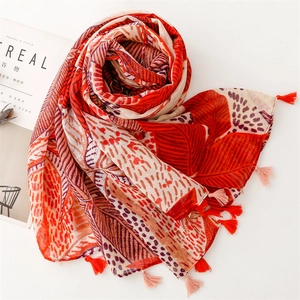 Detail of orange leaf pattern scarf with soft cotton feel and bicolor tassels