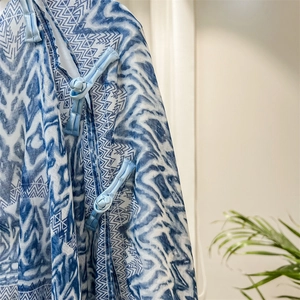 Close-up of traditional Chinese knots on a lightweight blue geometric print shawl scarf
