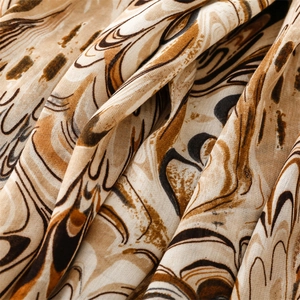 Close-up of lightweight linen cotton scarf showing brown abstract floral patterns