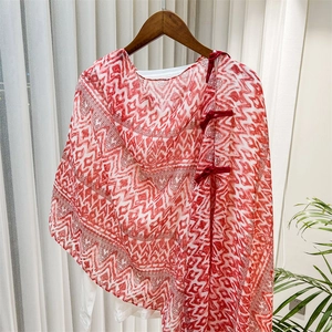 Detail of red geometric print shawl featuring traditional Chinese button closure