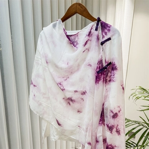 Detail of traditional Chinese frog buttons on a white and purple tie-dye shawl wrap