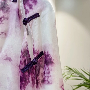 Detail of traditional Chinese frog buttons on a purple tie-dye silk shawl fabric