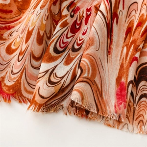 Close-up of phoenix tail pattern on soft linen scarf with delicate fringe edges