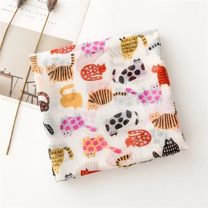 Detail of cotton linen scarf featuring colorful cartoon cat patterns and soft texture