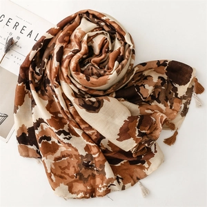 Detailed view of the soft cotton-linen scarf featuring leopard print and fringe accents