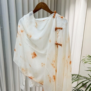 Detailed view of white tie-dye shawl with traditional Chinese frog button closures