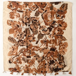 Detailed view of hand-painted floral patterns and fringe edges on a thick brown shawl