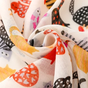 Close-up of soft cotton scarf fabric with colorful cartoon cat print and mesh texture