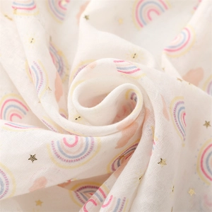 Détail macro d'une écharpe en coton blanc avec étoiles dorées et arc-en-ciel