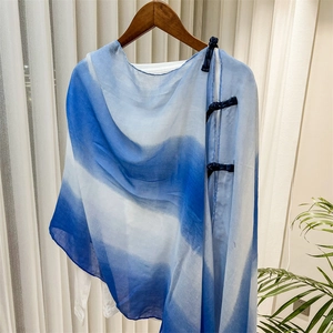 Detailed view of blue gradient Chinese shawl with traditional button on white shirt