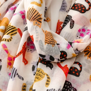 Close-up of linen-feel scarf fabric with colorful cartoon cat print and soft texture