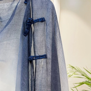Detail of traditional Chinese frog fastener on dark blue breathable linen shawl fabric