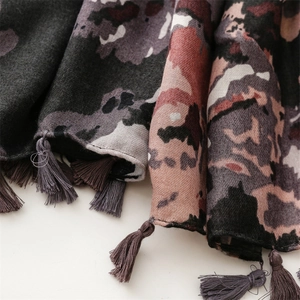 Detail of soft winter scarf with purple leopard print and handmade tassel trim