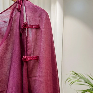 Detailed macro view of retro wine red shawl featuring traditional Chinese knot buttons