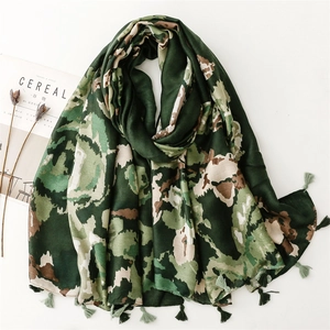 Thick dark green camouflage scarf with delicate tassels on a minimalist white background