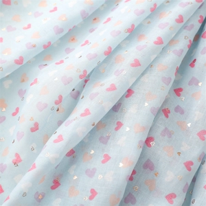 Macro shot of light blue cotton linen scarf with colorful hearts and gold foil accents