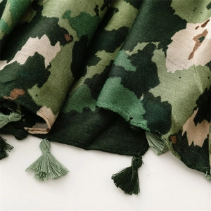 Detail of green camouflage and floral print scarf featuring fine woven tassel fringes