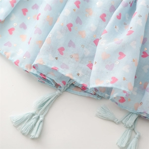 Close-up of light blue scarf with gold foil hearts and fringe tassel edges