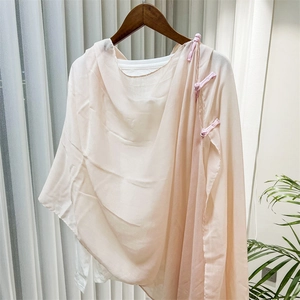 Detail view of light pink translucent shawl with traditional Chinese velvet knot buttons