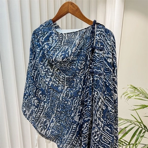 Detail of traditional Chinese knot buttons on blue and white geometric print shawl