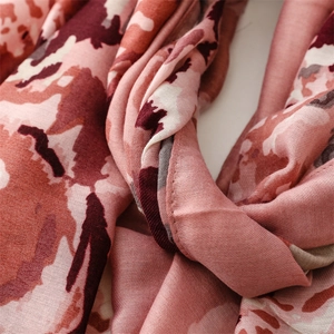 Detail view of pink abstract floral printed scarf showing soft texture and stitching