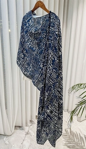 Detail showing blue and white floral print shawl with lightweight texture on wooden hanger