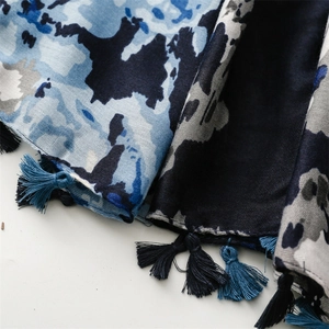 Close-up of abstract camouflage scarf featuring delicate blue and grey tassels