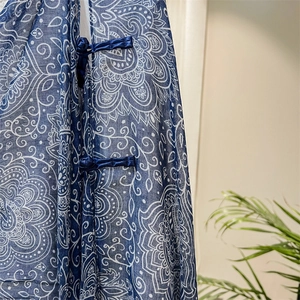 Detail of traditional Chinese knot buttons on navy blue paisley print silk scarf shawl