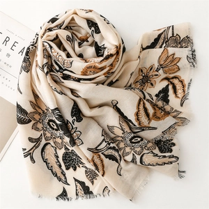 Détail d'un châle effet lin avec imprimé floral et finitions délicates à franges