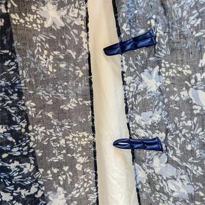 Detail of dark floral chiffon scarf with traditional blue satin frog button closure