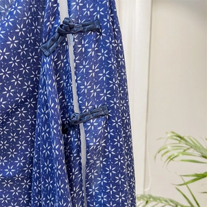 Detail of traditional Chinese knot buttons on a navy blue silk scarf with star prints