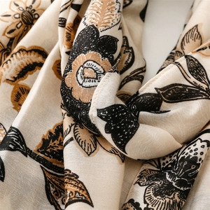 Gros plan détaillé d'une écharpe en coton et lin avec motif floral pivoine et texture douce
