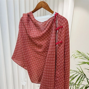 Detail of red floral Chinese shawl featuring traditional frog button closure design