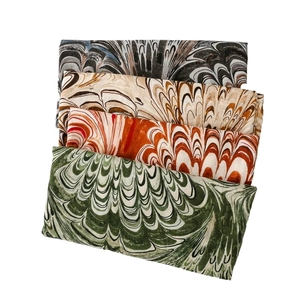 Folded cotton linen scarves with paisley flame patterns in various vibrant colors